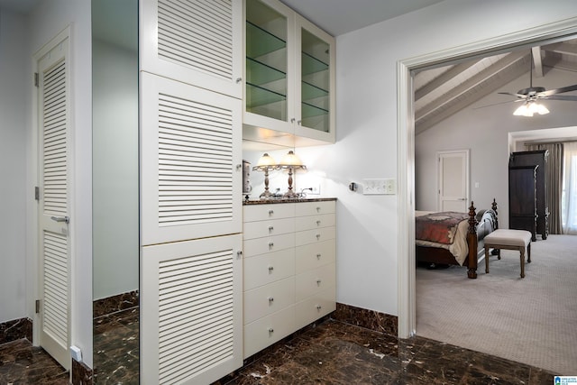 interior space with marble finish floor, lofted ceiling with beams, and baseboards