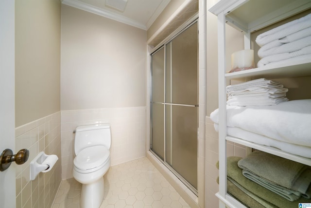 bathroom featuring ornamental molding, a shower stall, tile walls, and tile patterned floors