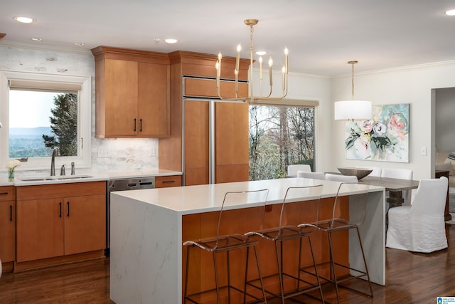 kitchen featuring dark wood-type flooring, a wealth of natural light, light countertops, and a sink