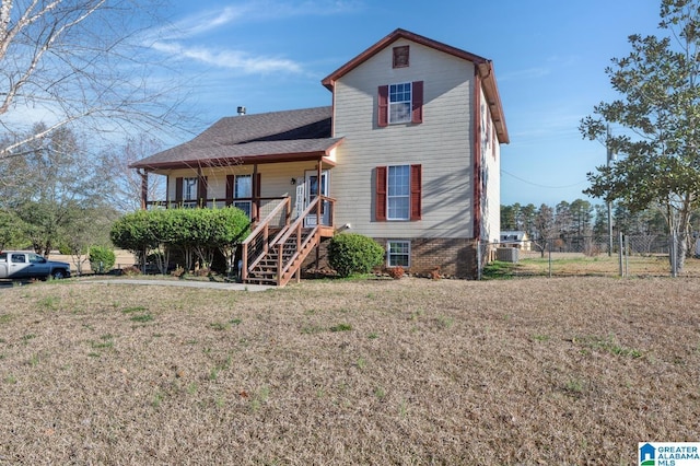 view of front of home with a front lawn, stairway, and fence
