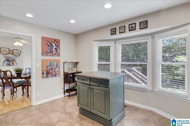 kitchen featuring recessed lighting, a healthy amount of sunlight, a kitchen island, and gray cabinetry