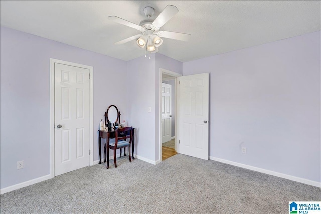 unfurnished bedroom featuring carpet floors, baseboards, and a ceiling fan