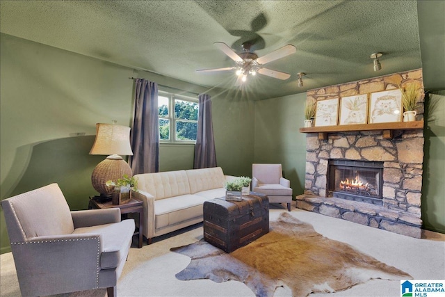 carpeted living area featuring a ceiling fan, a stone fireplace, and a textured ceiling