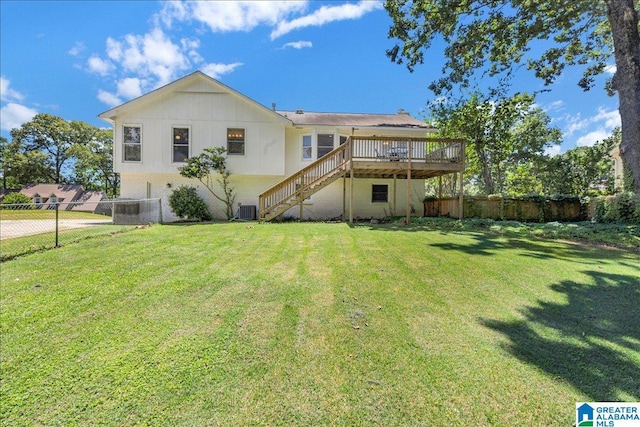 back of house featuring stairs, a deck, a lawn, and fence