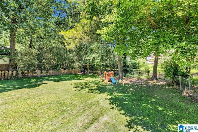 view of yard with a fenced backyard and a playground