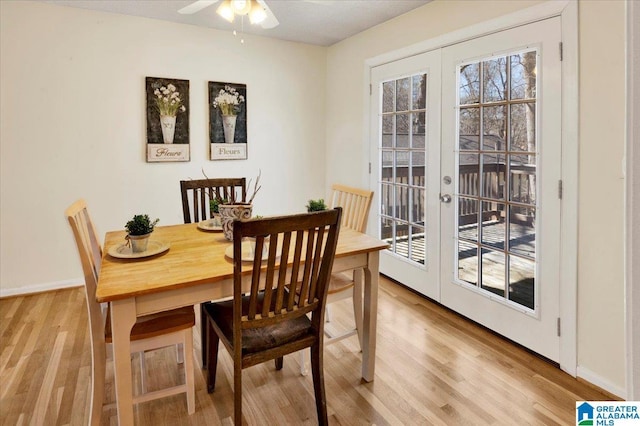 dining room featuring light wood-style floors, french doors, ceiling fan, and baseboards