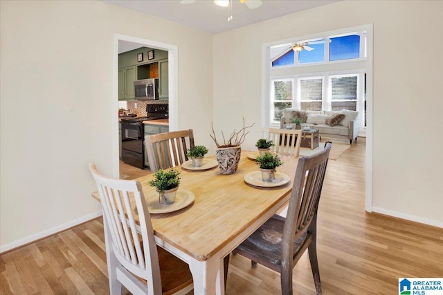 dining area featuring ceiling fan, baseboards, and light wood-style floors