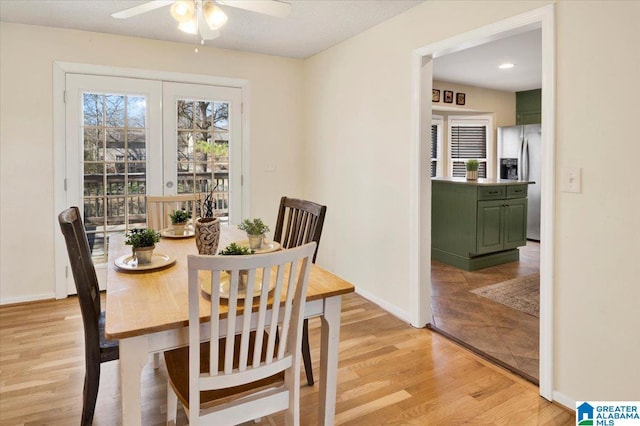 dining space with ceiling fan, french doors, light wood finished floors, and baseboards