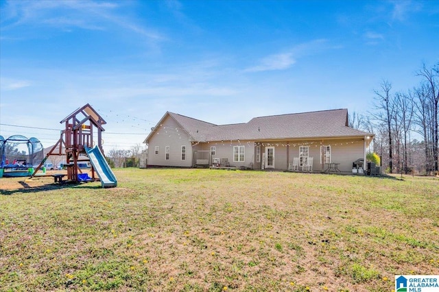 back of house with a yard and a playground