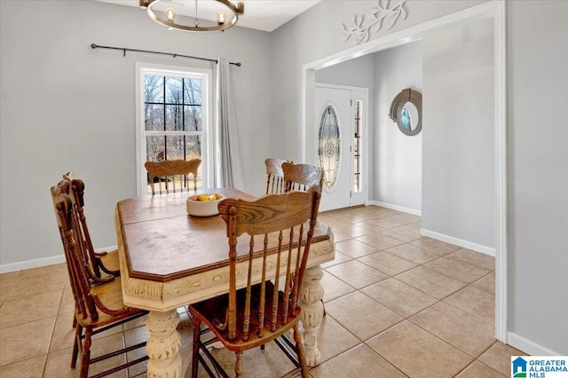 dining room with light tile patterned floors, an inviting chandelier, and baseboards