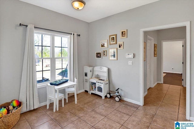 interior space with light tile patterned floors and baseboards