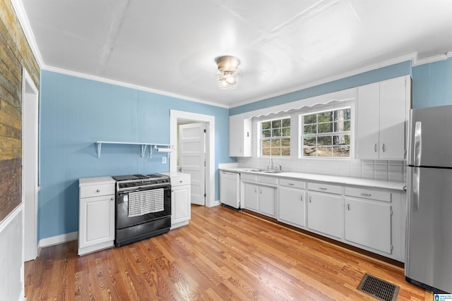 kitchen with gas range oven, light countertops, visible vents, freestanding refrigerator, and dishwasher