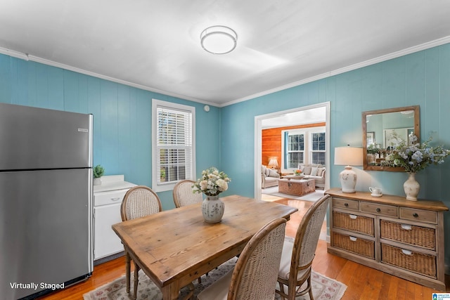 dining space featuring ornamental molding and hardwood / wood-style floors