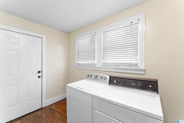 clothes washing area with laundry area, washer and clothes dryer, dark wood finished floors, and baseboards