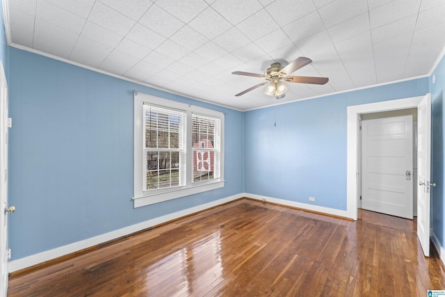 spare room with a ceiling fan, crown molding, baseboards, and hardwood / wood-style flooring