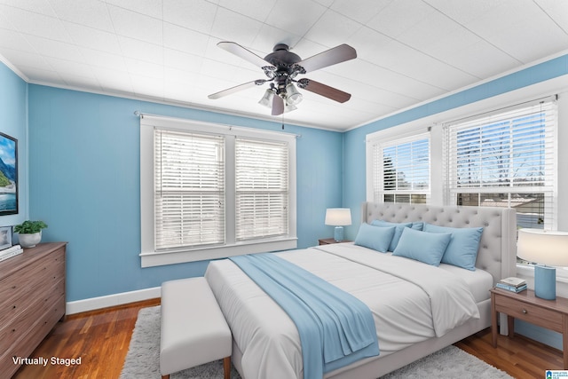 bedroom featuring baseboards, ornamental molding, ceiling fan, and wood finished floors