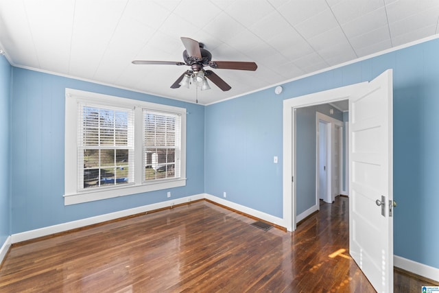 unfurnished room with baseboards, crown molding, visible vents, and wood finished floors