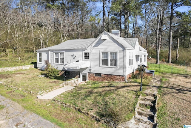 view of front of home with metal roof and a front yard