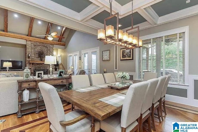 dining room featuring a wainscoted wall, wood finished floors, ornamental molding, french doors, and beamed ceiling