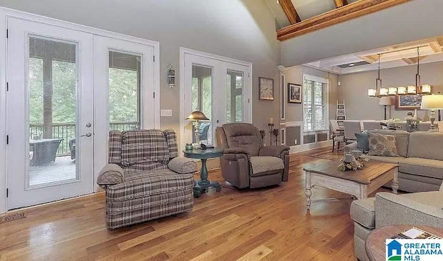 living area featuring light wood finished floors, french doors, visible vents, and a healthy amount of sunlight