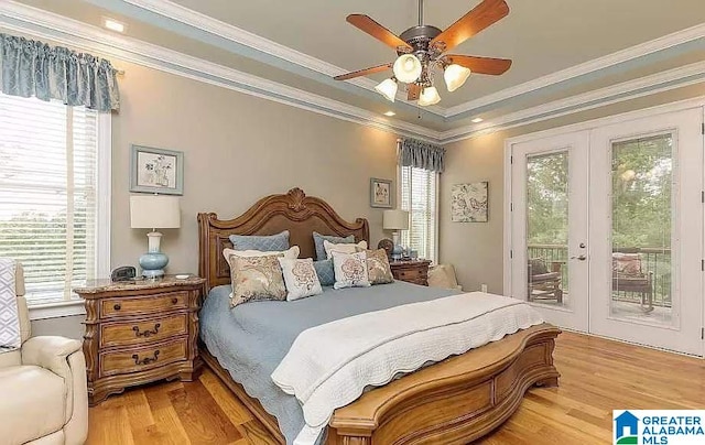 bedroom with light wood-type flooring, access to outside, and multiple windows