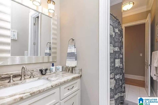 bathroom with ornamental molding, tile patterned flooring, vanity, and baseboards