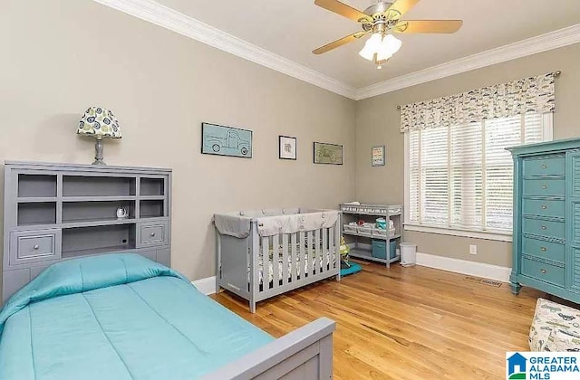 bedroom with ornamental molding, light wood-style flooring, baseboards, and a ceiling fan