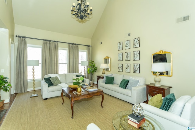 living area with high vaulted ceiling, baseboards, visible vents, and a notable chandelier