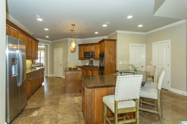 kitchen featuring brown cabinets, stainless steel appliances, tasteful backsplash, a kitchen island, and a sink