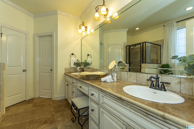 full bathroom with double vanity, a shower stall, ornamental molding, and a sink