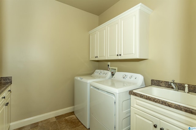 laundry room featuring a sink, baseboards, independent washer and dryer, cabinet space, and tile patterned floors