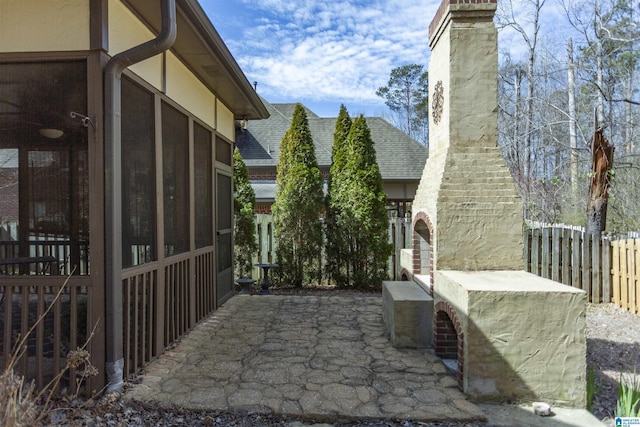 view of patio featuring a sunroom and fence