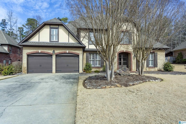 view of front facade with a shingled roof, concrete driveway, french doors, and stucco siding