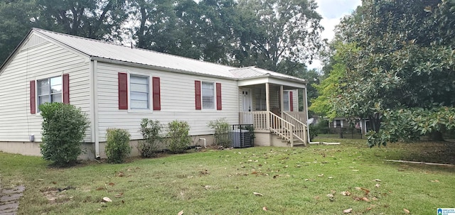 view of front facade featuring metal roof and a front lawn