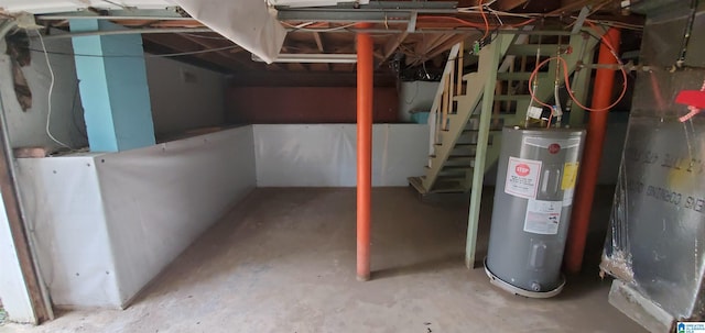 unfinished below grade area featuring water heater and stairway