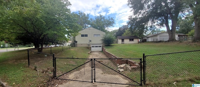 view of yard featuring an outbuilding, an attached garage, a gate, fence, and driveway