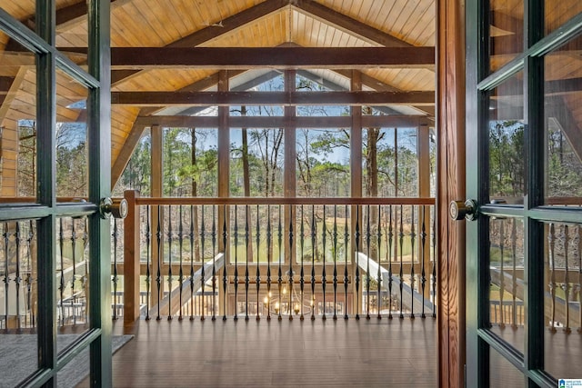 unfurnished sunroom with wood ceiling, plenty of natural light, and lofted ceiling with beams