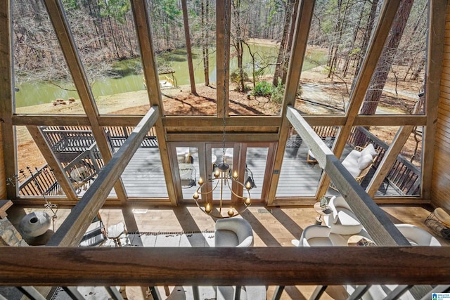 unfurnished sunroom featuring a water view and an inviting chandelier