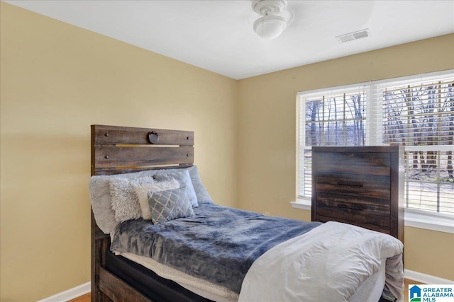 bedroom featuring baseboards and visible vents