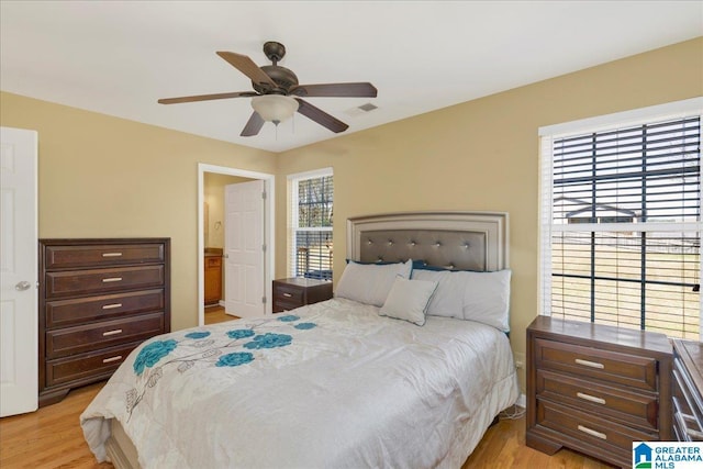 bedroom with light wood-style flooring, visible vents, and ceiling fan