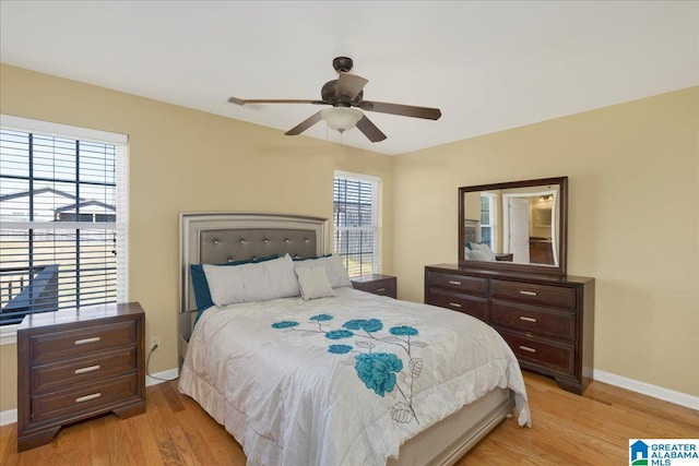 bedroom featuring visible vents, ceiling fan, light wood-style flooring, and baseboards