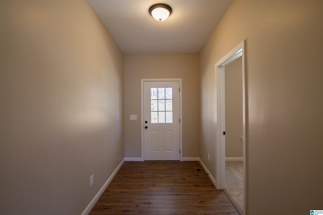 doorway with baseboards and wood finished floors