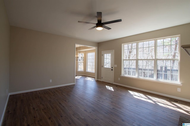 interior space featuring dark wood-type flooring, plenty of natural light, and baseboards