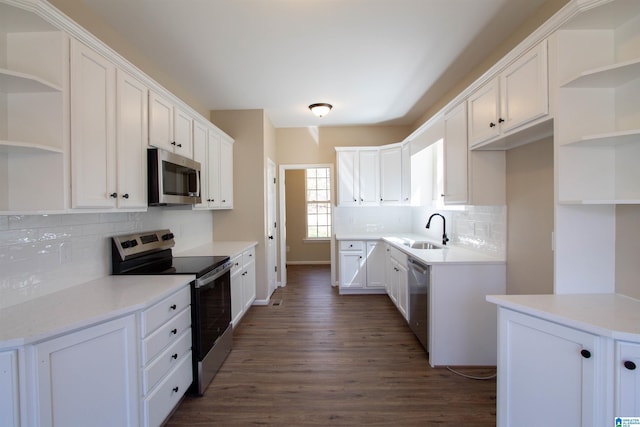 kitchen featuring open shelves, appliances with stainless steel finishes, a sink, and white cabinetry