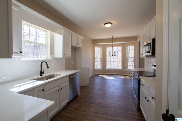 kitchen featuring appliances with stainless steel finishes, white cabinets, and a sink