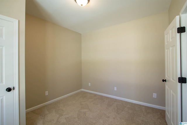 spare room featuring carpet floors and baseboards