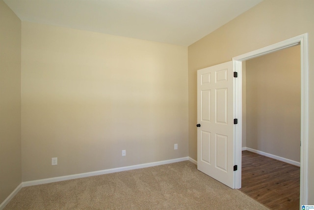 unfurnished room with light carpet and baseboards