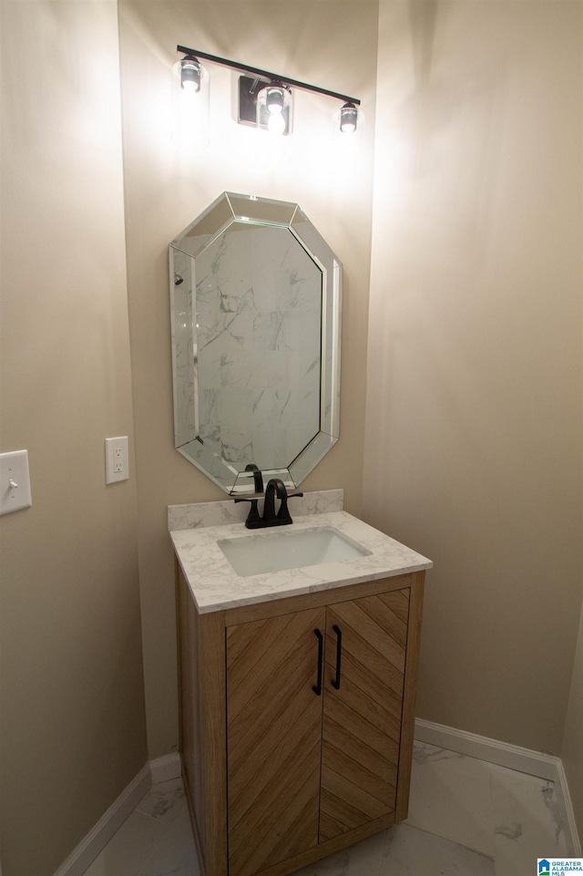 bathroom featuring marble finish floor, vanity, and baseboards