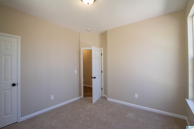 unfurnished bedroom with light carpet and baseboards