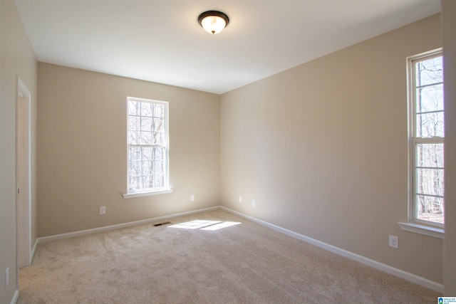 unfurnished room with carpet, plenty of natural light, and baseboards